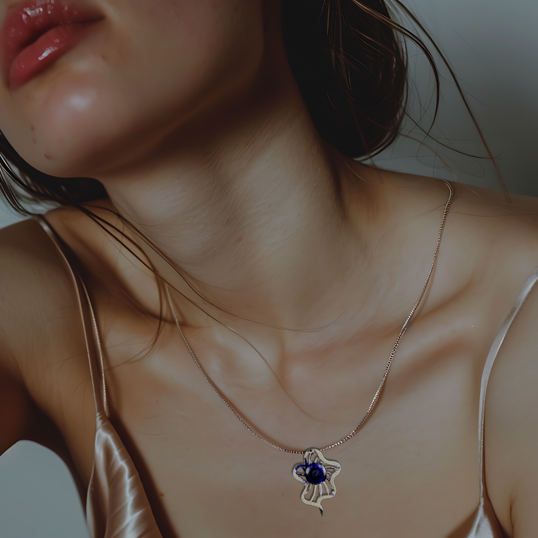 A woman wearing the Deep Blue Medusa Aromatherapy Necklace by Lilanimus, a silver diffuser necklace